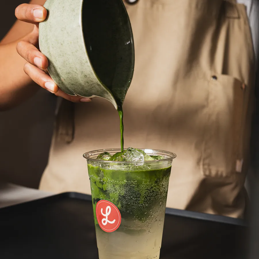 Matcha vertido sobre una bebida fría con hielo