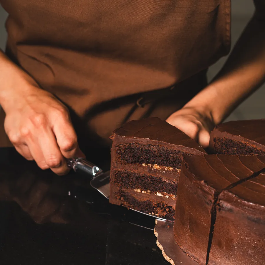 Rebanada de pastel de chocolate servida con espátula
